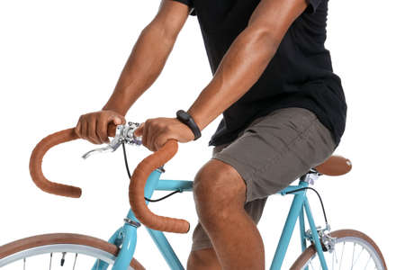 African-American teenage boy riding bicycle on white background