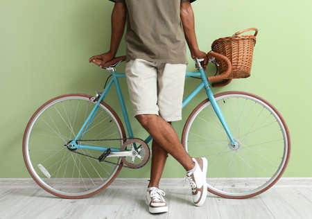 African-American teenage boy with bicycle near green wallの写真素材