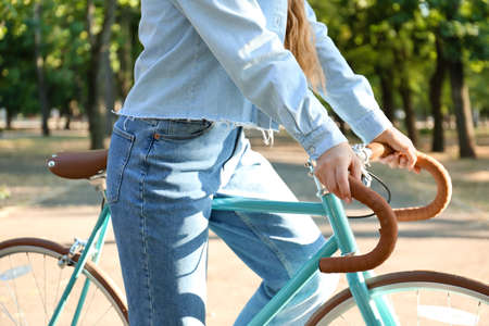 Pretty teenage girl with bicycle in park, closeupの写真素材