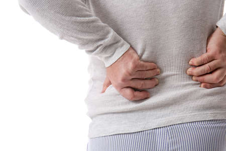 Senior man in sweater suffering from back pain on white background, closeup