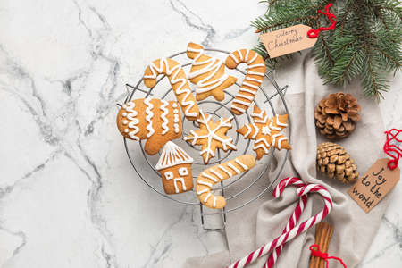 Stand with Christmas gingerbread cookies on light background