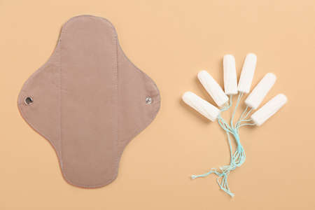 Reusable menstrual pad and tampons on gray background