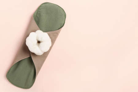 Reusable menstrual pad and cotton flower on pink backgroundの写真素材