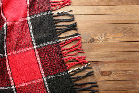 Soft plaid for picnic on wooden background