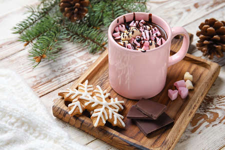 Cup of tasty hot chocolate with marshmallow and cookies on white wooden background