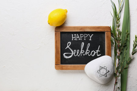 Chalkboard with text HAPPY SUKKOT and festival symbols on light backgroundの写真素材