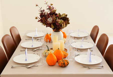 Beautiful autumn table setting with pumpkins and protea flowers at restaurantの写真素材