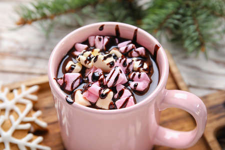 Cup of tasty hot chocolate with marshmallow on table, closeup