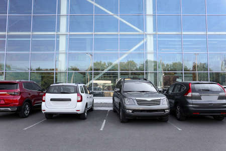 Cars parked in parking lot near business center in city