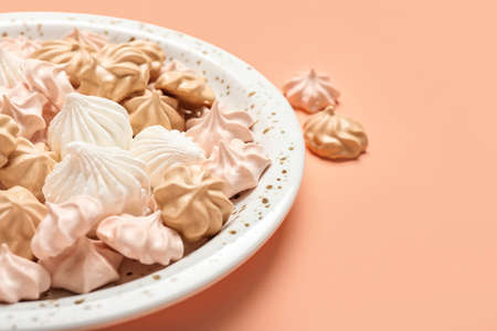 Plate with sweet meringue on color background, closeupの写真素材