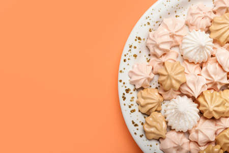 Plate with sweet meringue on color background, closeupの写真素材