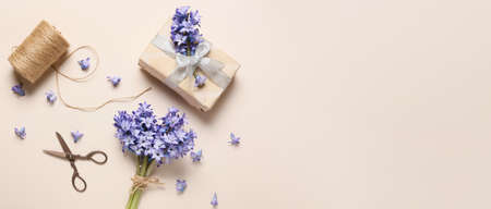 Composition with bouquet of beautiful hyacinth flowers and gift box on light background with space for textの写真素材