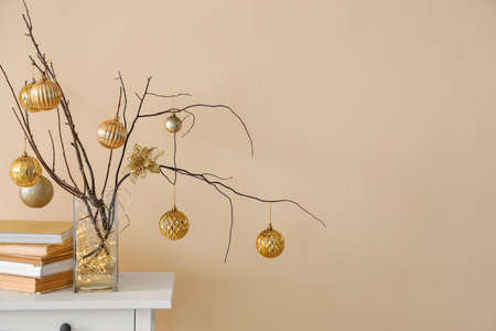 Christmas decoration with tree branches and festive balls on wall background