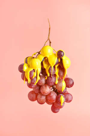 Fresh grapes with yellow paint on color backgroundの写真素材