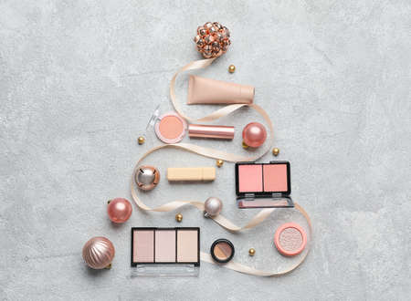 Tree made of makeup cosmetics with Christmas decor on light backgroundの写真素材