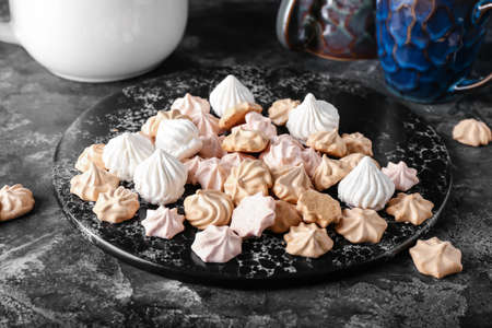 Board with tasty meringues on dark backgroundの写真素材
