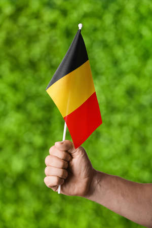 Male hand with Belgian flag on color backgroundの写真素材