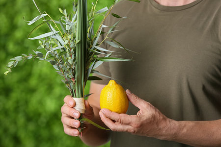 Man holding Sukkot festival symbols on green background, closeupの写真素材