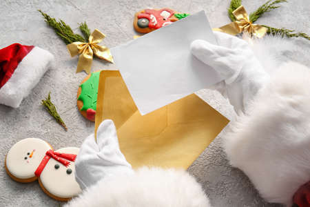 Santa Claus holding envelope and letter on gray table, closeupの写真素材