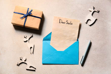 Wish list letter to Santa Claus with text DEAR SANTA in envelope on light backgroundの写真素材