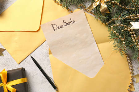 Christmas decor, pen, envelope and letter with text DEAR SANTA on light tableの写真素材