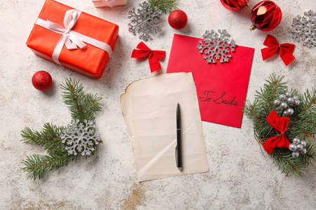 Christmas decor, blank letter, pen and envelope with text TO SANTA on light backgroundの写真素材