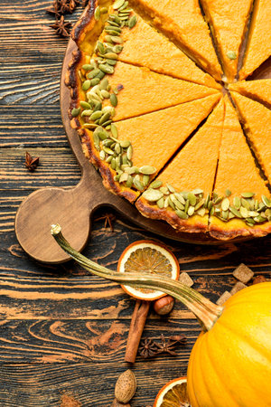 Board with delicious pumpkin pie on wooden backgroundの写真素材