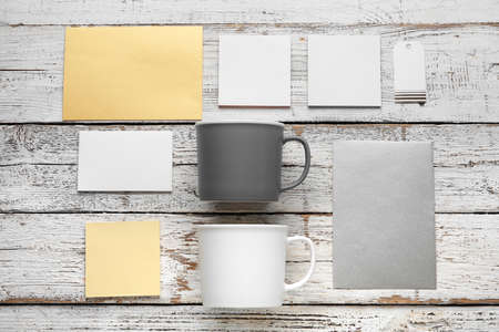 Composition with cups and blank cards on light wooden background