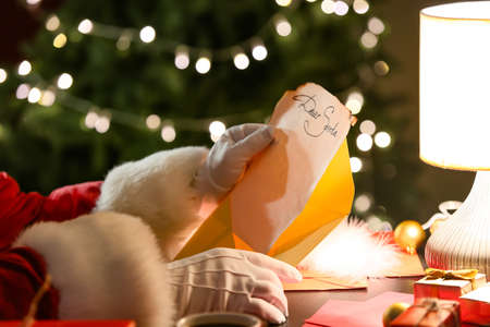 Santa Claus reading letter at table on Christmas eveの写真素材