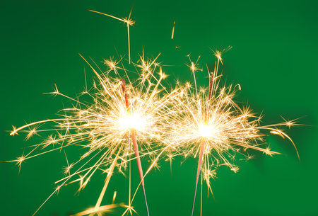 Burning Christmas sparklers on color backgroundの写真素材