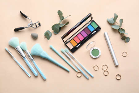 Set of decorative cosmetics with makeup brushes on color backgroundの写真素材