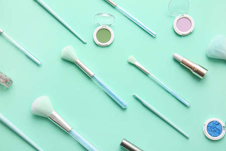 Set of decorative cosmetics with makeup brushes on color backgroundの写真素材