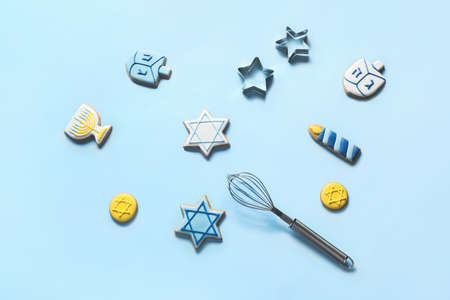 Tasty cookies for Hanukkah celebration on color background