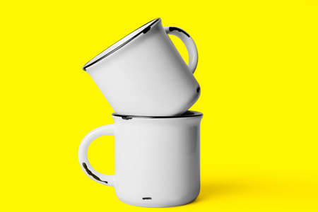 Two ceramic cups on yellow backgroundの写真素材