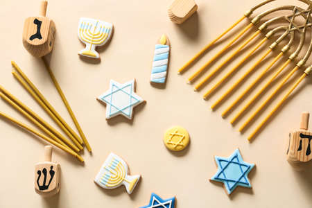 Tasty cookies for Hanukkah celebration with menorah, candles and dreidels on light backgroundの写真素材