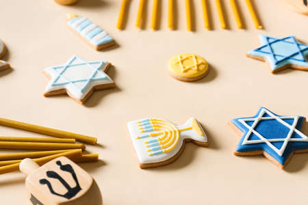 Tasty cookies for Hanukkah celebration with candles and sevivon on light backgroundの写真素材