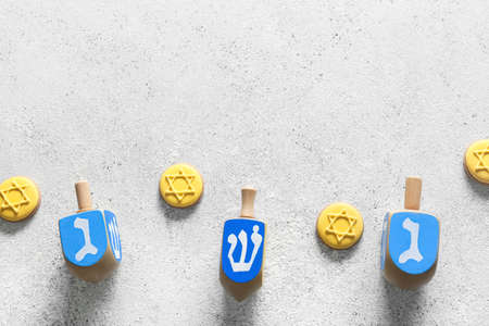 Tasty cookies for Hanukkah celebration and dreidels on gray backgroundの写真素材