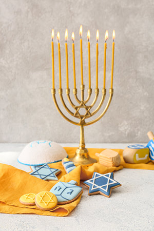 Tasty cookies for Hanukkah celebration with menorah on gray backgroundの写真素材
