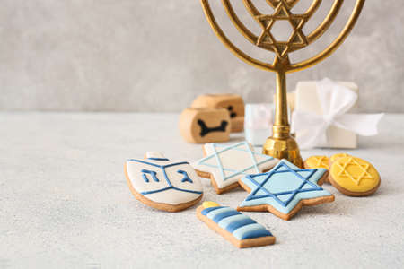Tasty cookies for Hanukkah celebration with menorah on gray backgroundの写真素材