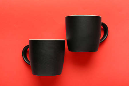 Black ceramic cups on red backgroundの写真素材