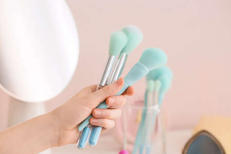 Woman holding set of makeup brushes, closeup