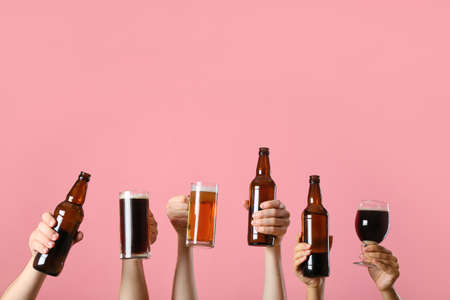 Hands with beer on color backgroundの写真素材
