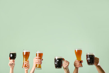 Hands with beer on color backgroundの写真素材