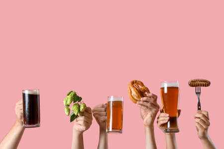 Hands with beer and snacks on color backgroundの写真素材