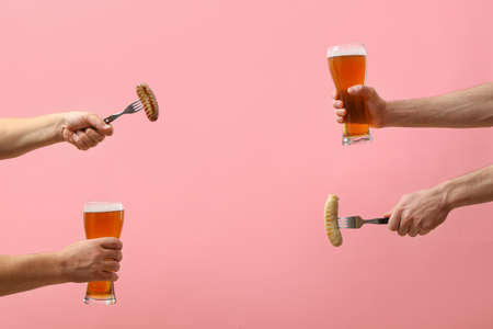 Hands with beer and snacks on color backgroundの写真素材