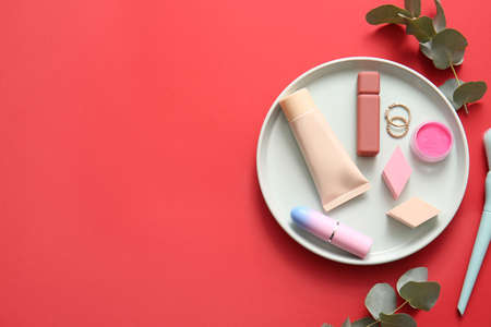 Plate with decorative cosmetics on red backgroundの写真素材