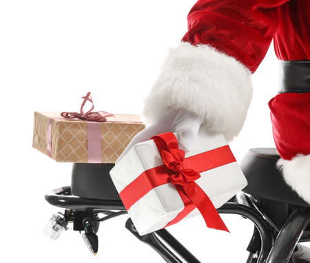 Santa Claus riding electric scooter with Christmas gifts on white background, closeupの写真素材
