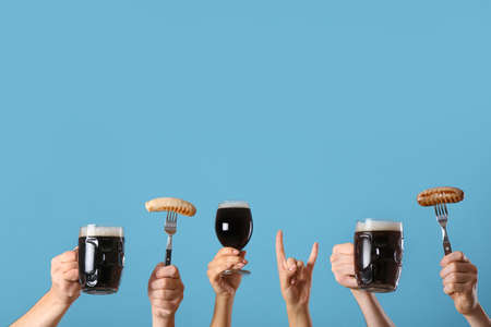 Hands with beer and snacks on color backgroundの写真素材