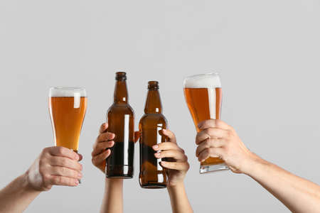 Hands with beer on gray backgroundの写真素材