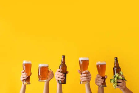 Hands with beer on color backgroundの写真素材